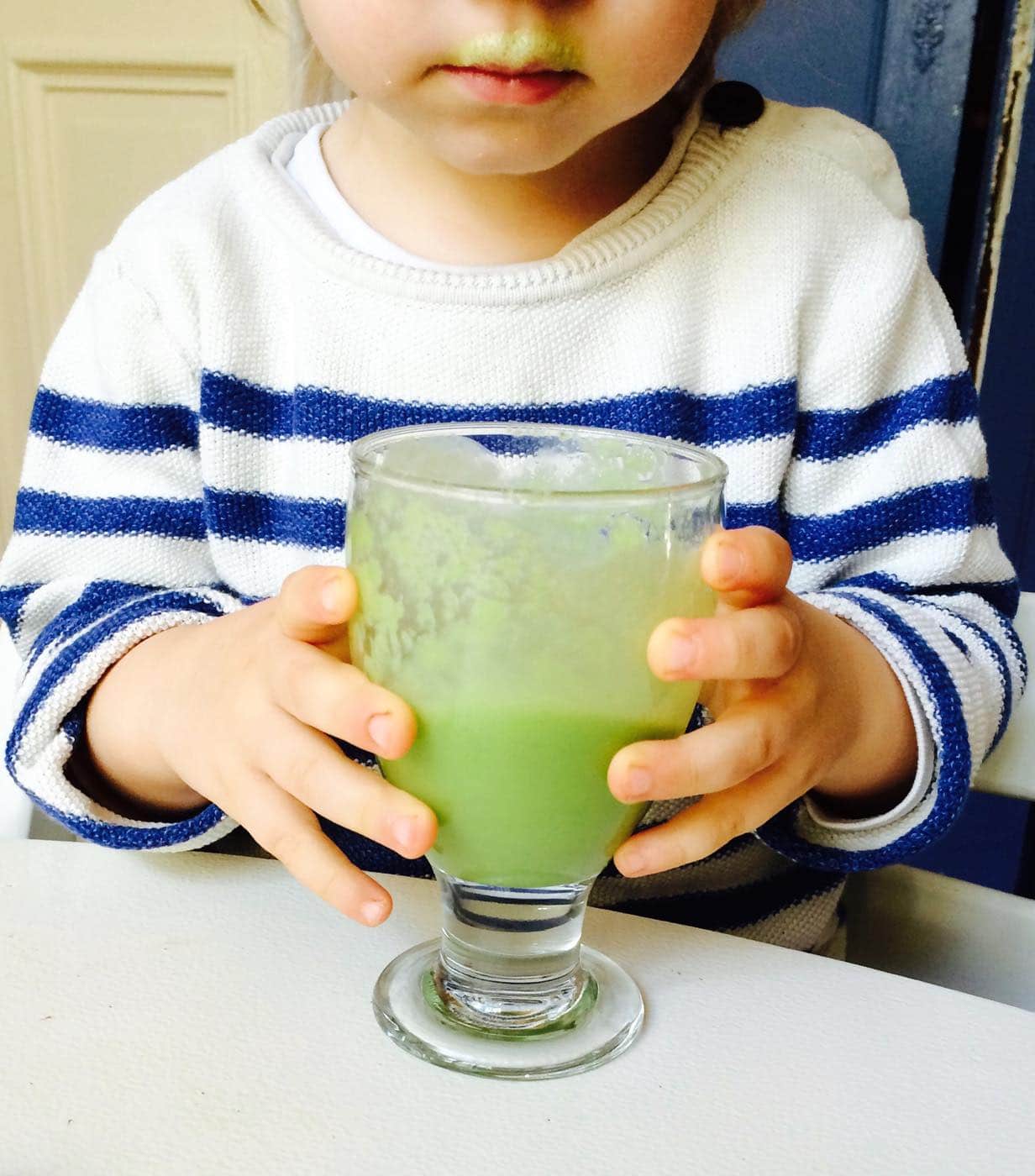Kind trinkt grünen Smoothie